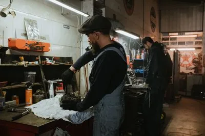 Indian mechanics working on vehicle fleet in garage